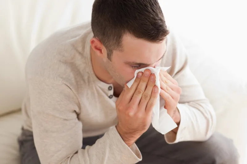 Ill man blowing his nose