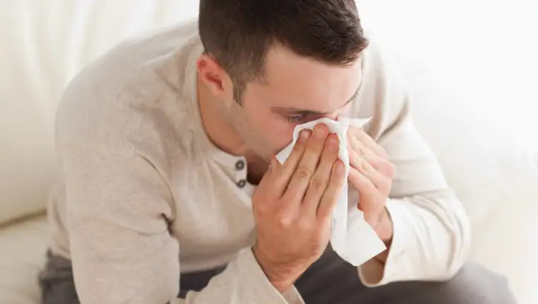 Ill man blowing his nose