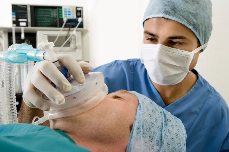 anaesthetist administering to a patient during surgery