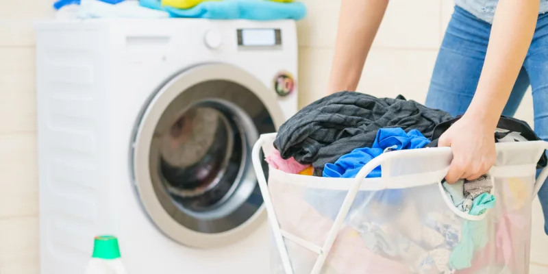 Woman holding laundry basket full of clothes