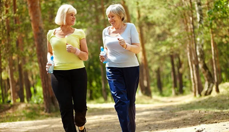 Portrait of two senior females running outdoors
