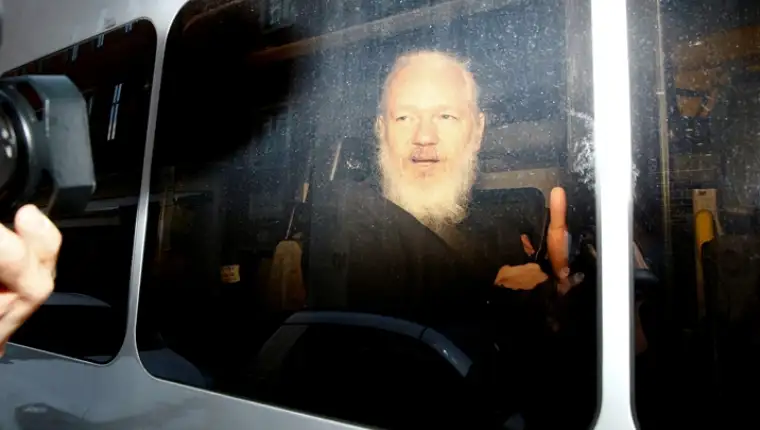 FILE PHOTO: WikiLeaks founder Julian Assange is seen in a police van, after he was arrested by British police, in London