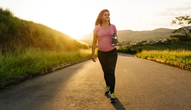 Pregnant woman walking at sunset on a desert road