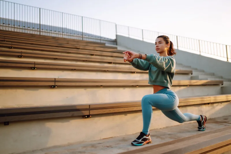 Fit Young woman in sportswear doing yoga, fitness exercise on the street.