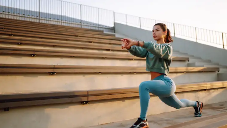 Fit Young woman in sportswear doing yoga, fitness exercise on the street.