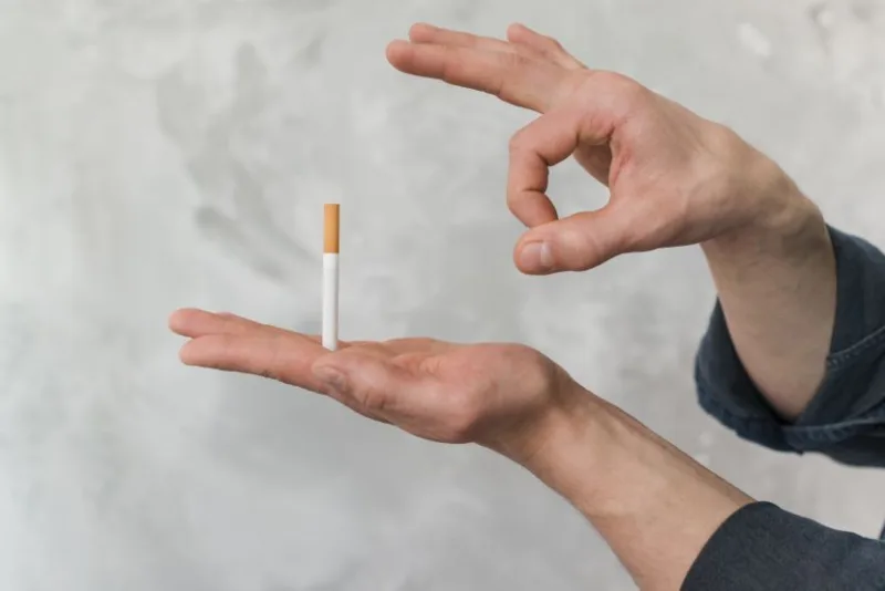 man-throwing-cigarette-through-finger-against-wall-830x0