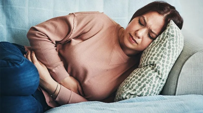 young-woman-with-stomach-pain-on-couch