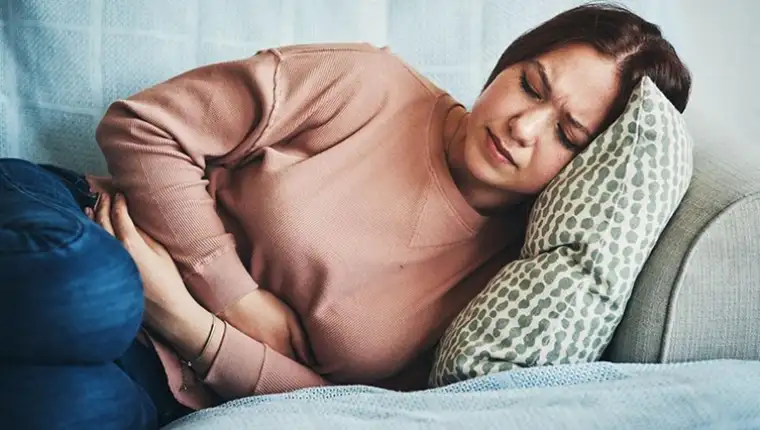 young-woman-with-stomach-pain-on-couch