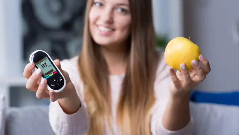 Holding glucometer and apple