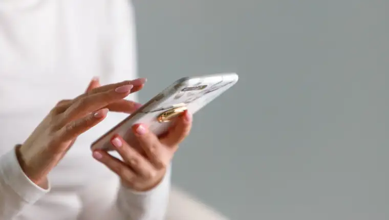 female hands typing text message, using modern smartphone device