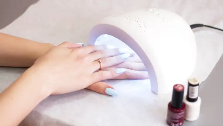 Woman using UV light dryer. Manicure, spa salon concept. Beauty and fashion.