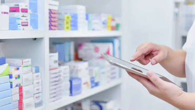 Pharmacist,Holding,Computer,Tablet,Using,For,Filling,Prescription,In,Pharmacy