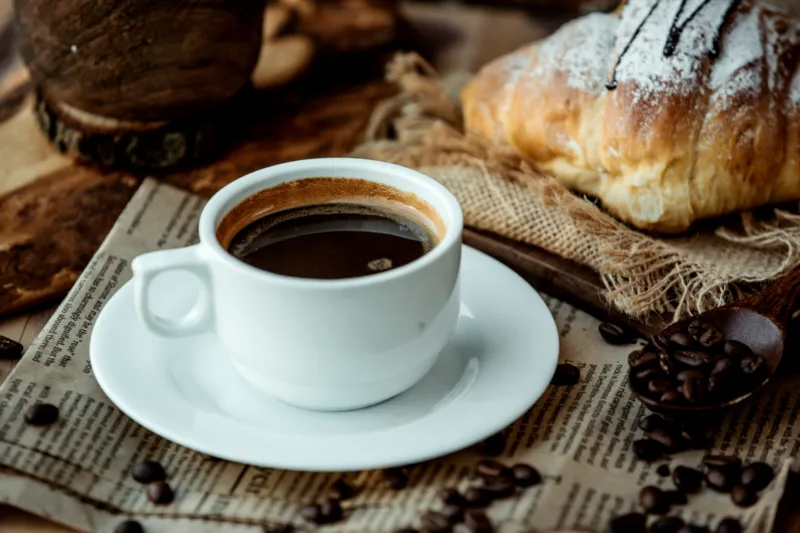 a cup of americano coffee placed on newspaper