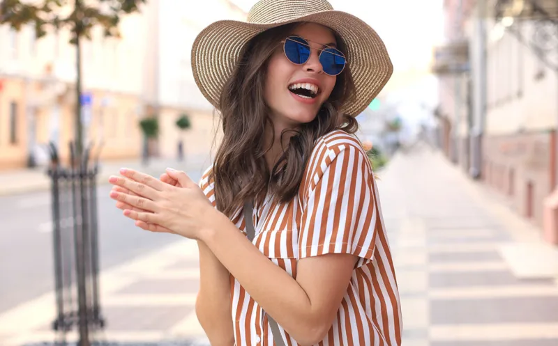Portrait fashion woman is posing in the city, summer street fashion. Laughing and smiling portrait.
