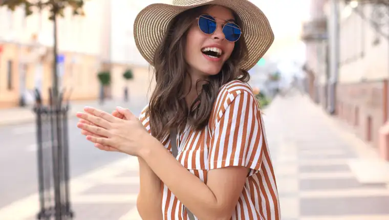 Portrait fashion woman is posing in the city, summer street fashion. Laughing and smiling portrait.