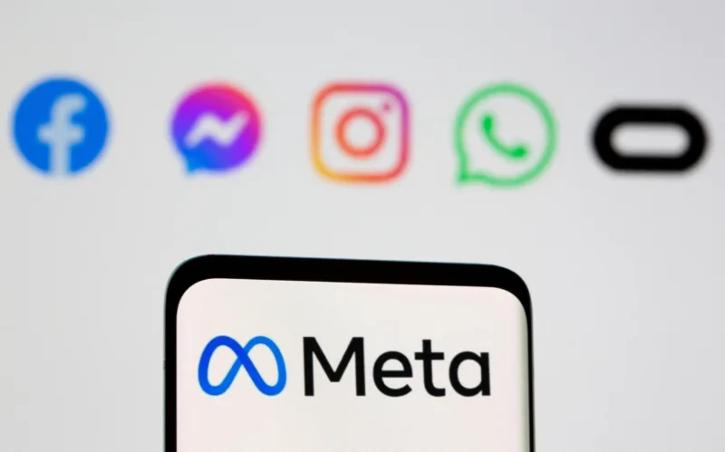 FILE PHOTO: Facebook's new rebrand logo Meta is seen on smartpone in front of displayed logo of Facebook, Messenger, Intagram, Whatsapp, Oculus in this illustration taken