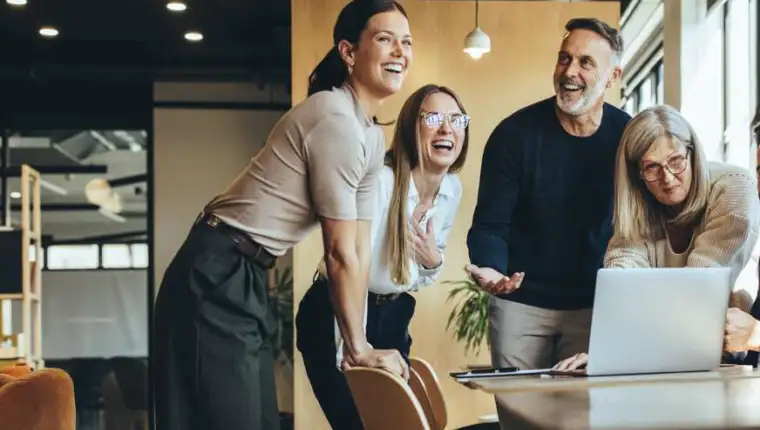 Happy,Businesspeople,Laughing,While,Collaborating,On,A,New,Project,In