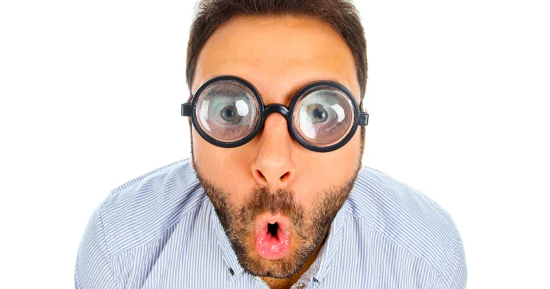 Man with a surprised expression and thick glasses.