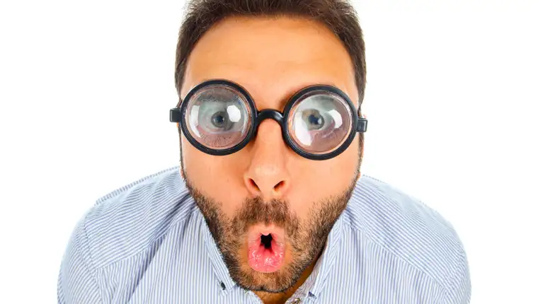 Man with a surprised expression and thick glasses.