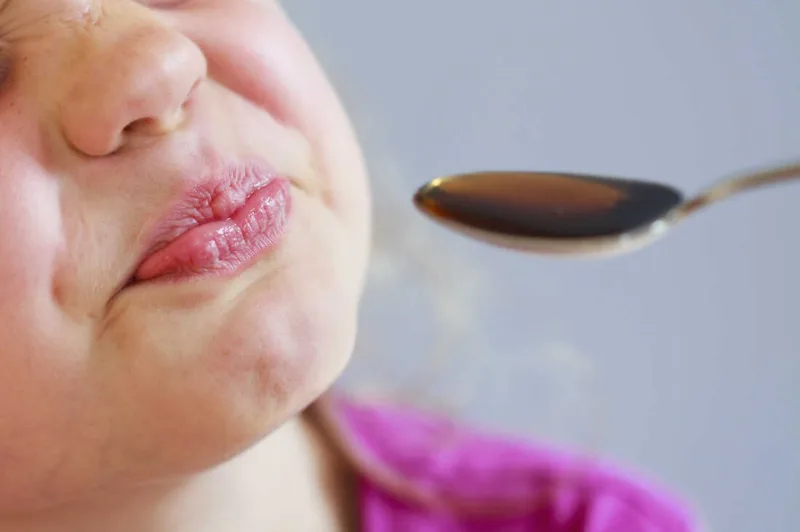 Bitter medicine and girl grimaces