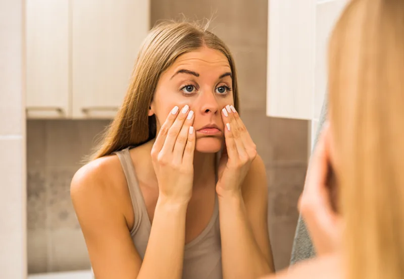 Tired,Woman,Looking,Her,Eye,Bags,In,The,Bathroom.