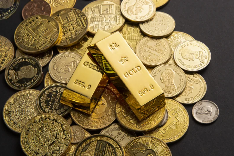 Coins, and gold bars scattered on a table