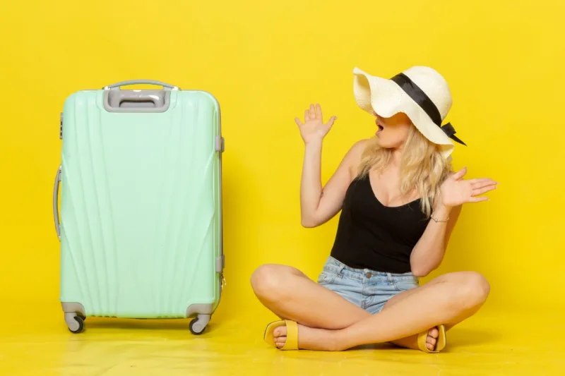 front-view-young-female-sitting-along-with-her-green-bag-yellow-desk-trip-vacation-sun-voyage-journey-girl