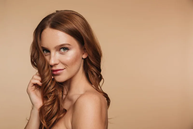Beauty portrait of mystery smiling ginger woman with long hair