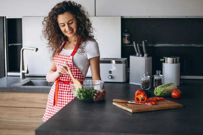 Woman making salad at the kitchen