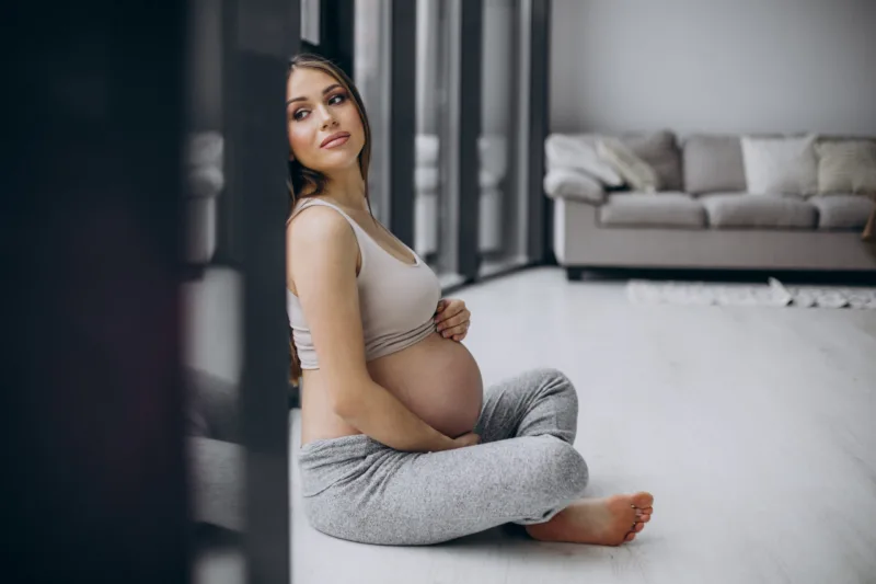 Pregnant woman having rest after exercising at home