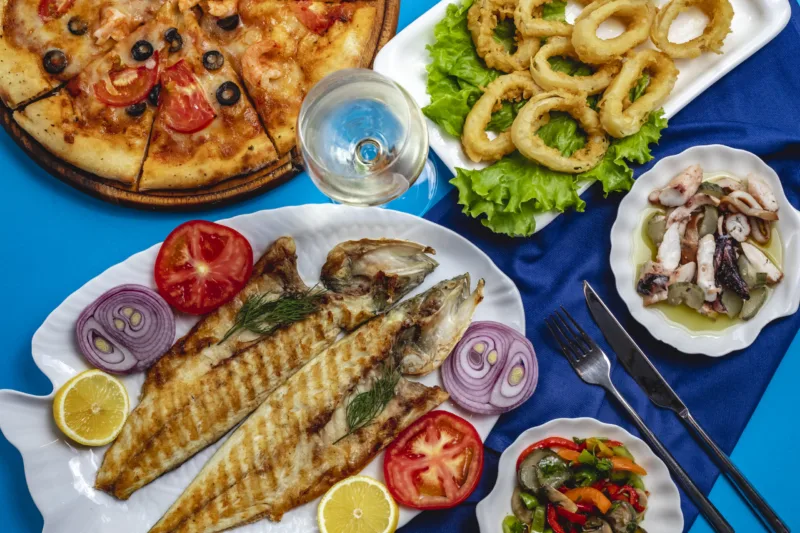 grilled fish onion tomato calamary green salad top view