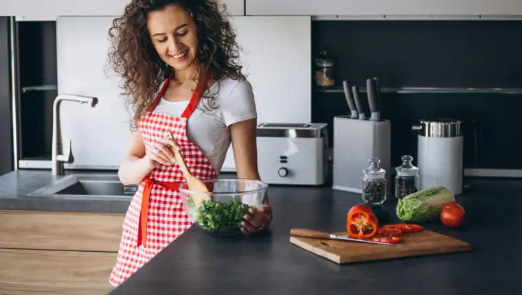 Woman making salad at the kitchen