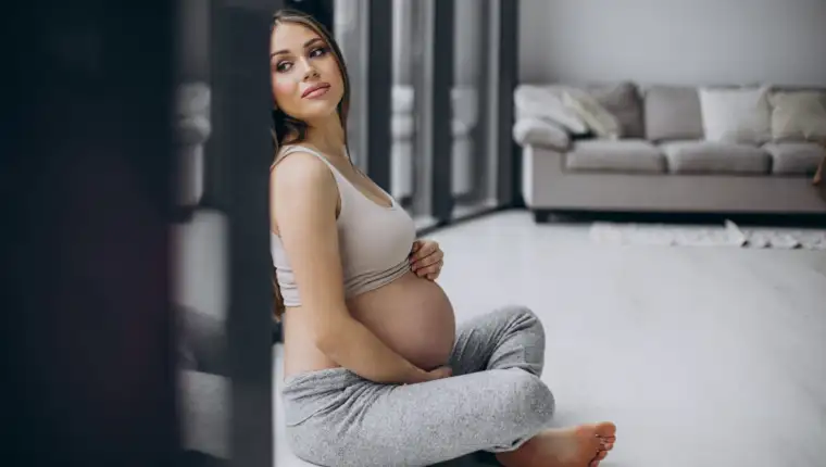 Pregnant woman having rest after exercising at home