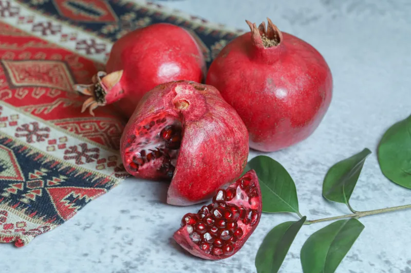 Fresh ripe pomegranates on stone background