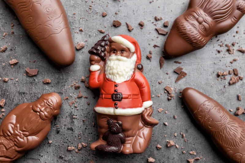 Delicious Christmas chocolate and sweets on rustic background