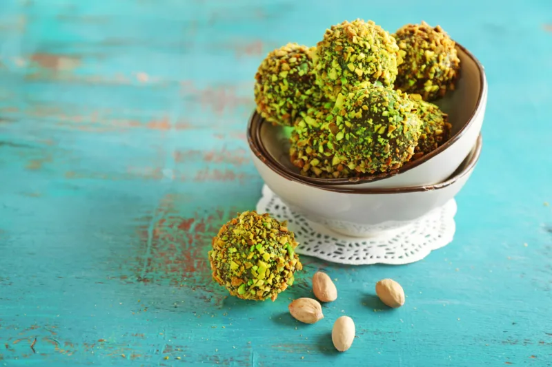 Tasty homemade pistachio candies on wooden table