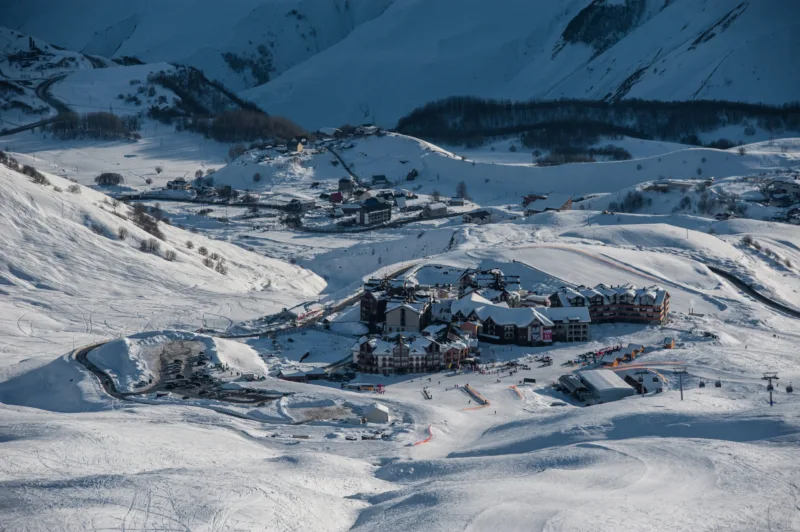 Snowy winter mountains in sun day. Georgia, from ski resort Guda