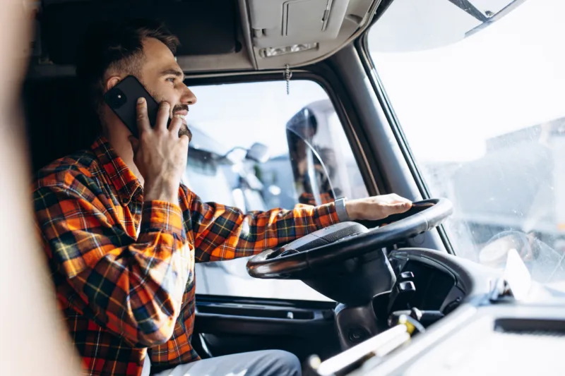 Man trucker driving in a cabin of his truck