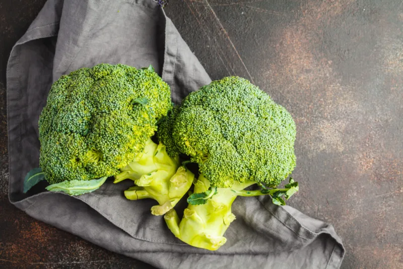 Sliced raw broccoli isolated on a dark background, top view, cop