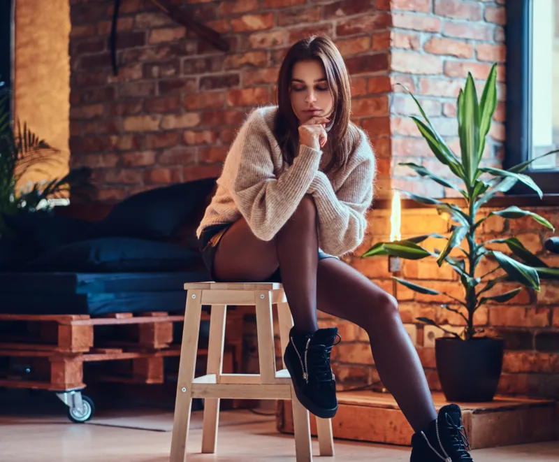 A woman posing near the window.