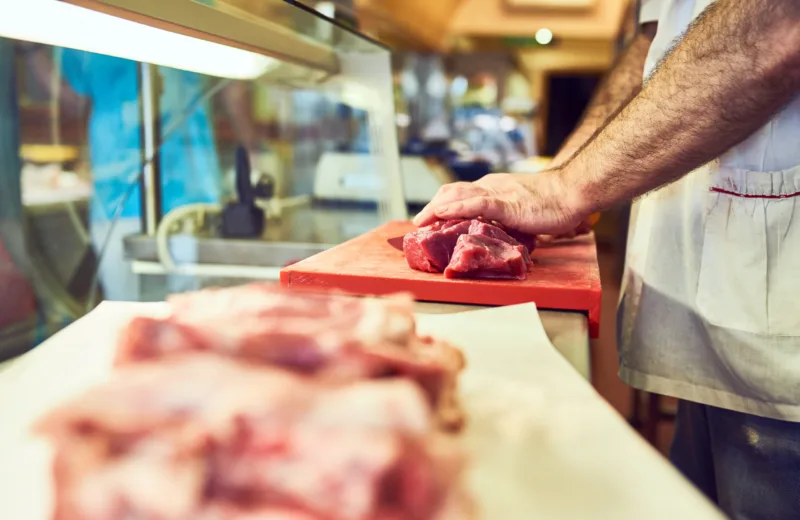 Meat is meat and a man must eat. a butcher at his store.