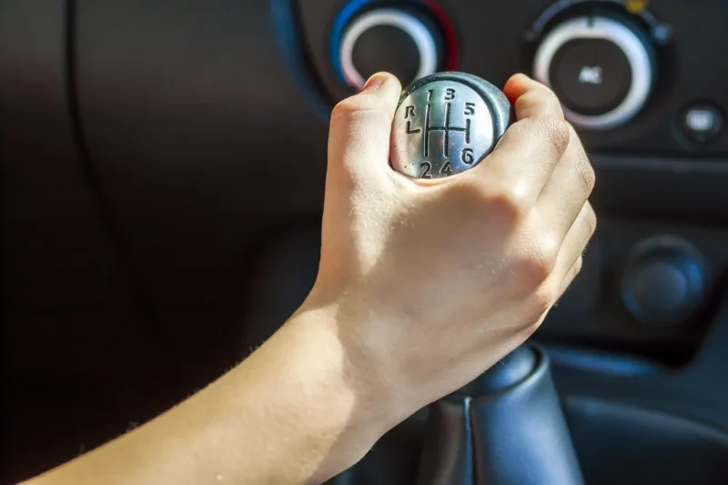 Driver hand shifting gear shift knob manually, selective focus