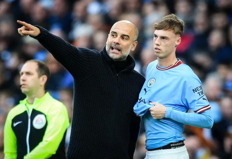 Pep-Guardiola-Manchester-City-Manager-speaks-with-Cole-Palmer-Premier-League-April-15-2023