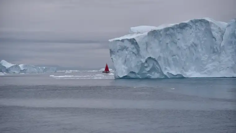 scenic-view-red-sails-against-huge-icebergs