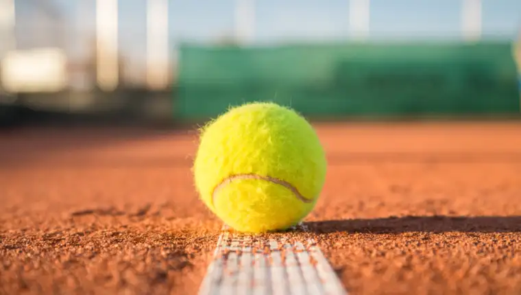 tennis-ball-lying-white-line-tennis-court-sunny-day-scaled-1170x659