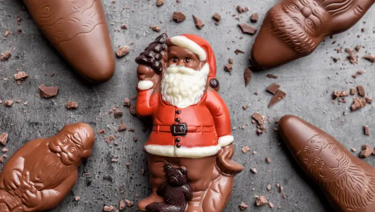 Delicious Christmas chocolate and sweets on rustic background