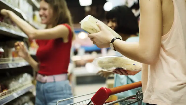 Women choosing food from a supermarket shelf