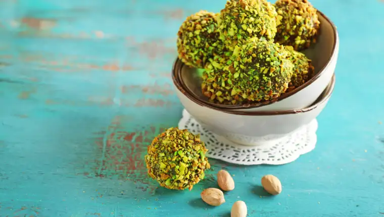 Tasty homemade pistachio candies on wooden table