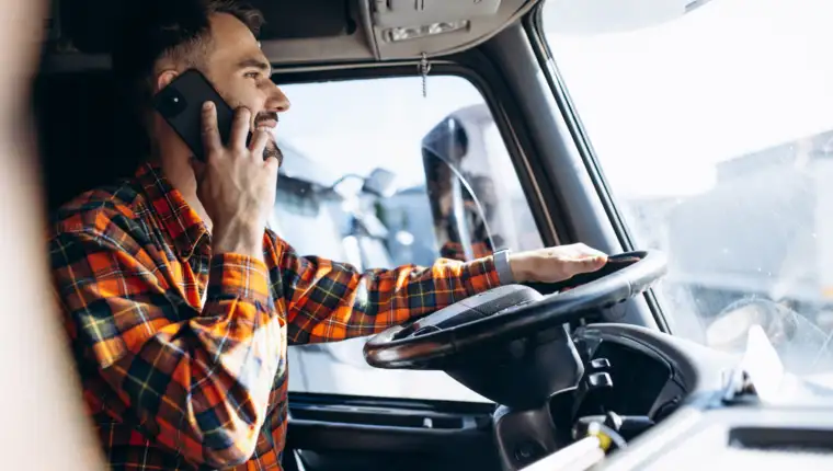 Man trucker driving in a cabin of his truck