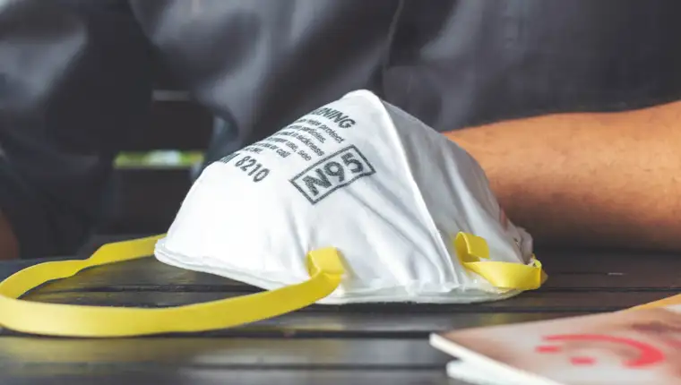 closeup N95 air filter mask. personal protective equipment in office with soft-focus and over light in the background